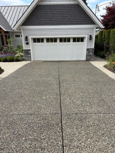A freshly sealed exposed aggregate driveway in Victoria, BC, showcasing a rich "wet look" finish and professional protection against moss and salt damage.