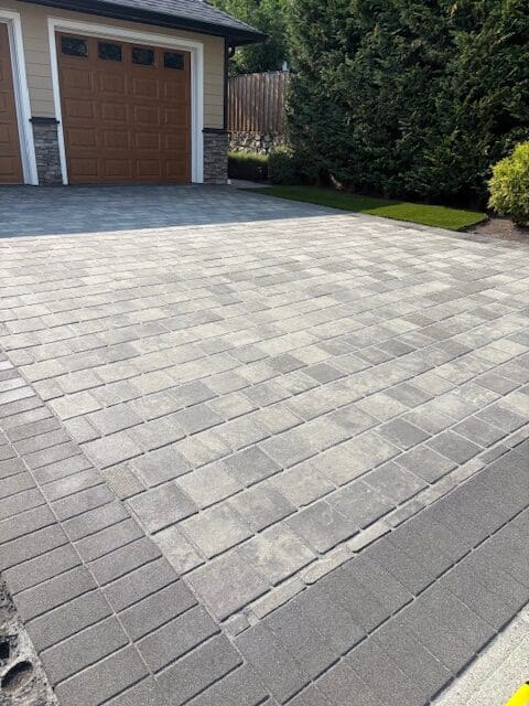 A wide view of a clean, professionally sealed multi-tone paver driveway in Victoria, BC, showcasing a high-quality finish and enhanced curb appeal.